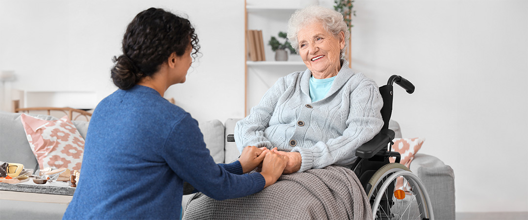 a woman holding hands with a woman in a wheelchair